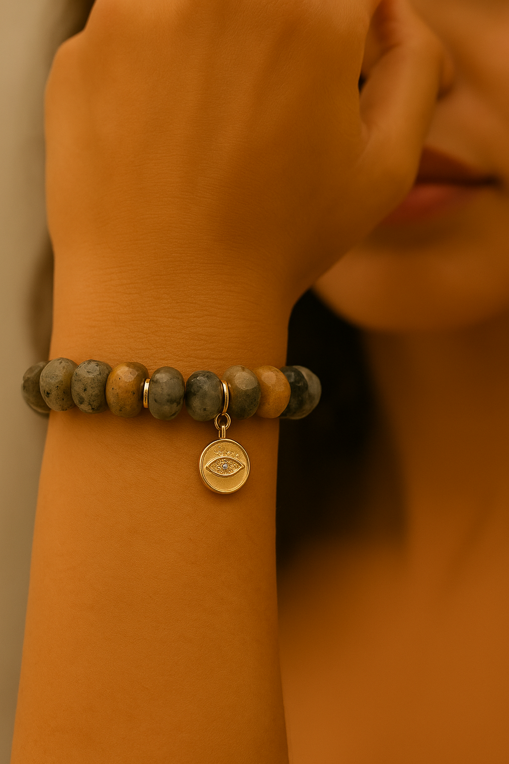 Woman wearing a beaded bracelet with gold evil eye charm on wrist