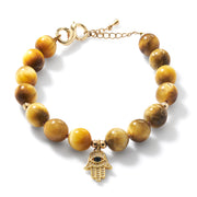 Tiger’s eye beaded bracelet with gold hamsa hand charm on white background