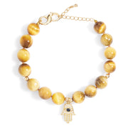 Tiger eye beaded bracelet with gold Hamsa hand charm on white background