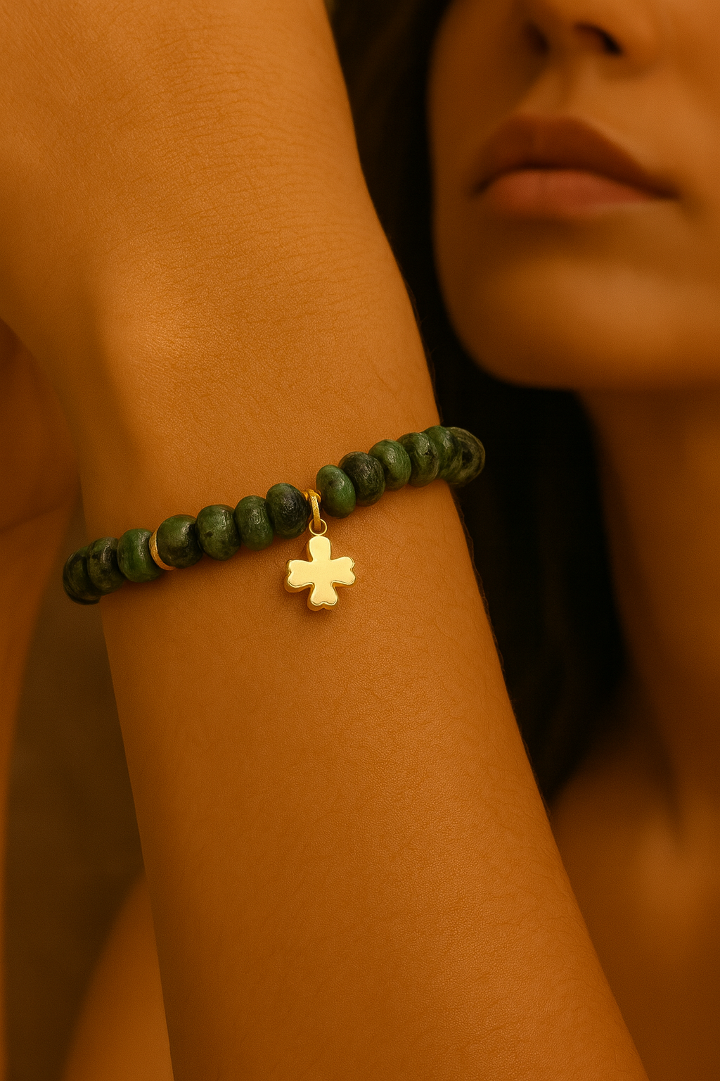 Emerald bead bracelet with gold clover charm on woman's wrist